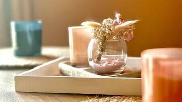 A candle holder with dried flowers on a tray.