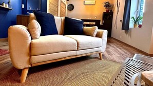 A living room with a beige sofa, a woven rug, and a wooden ceiling. - Hour House 2 - Honeymoon (Houyet)