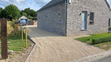 A stone building with a gravel driveway and a small garden area.