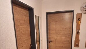 A hallway with wooden doors and a wooden floor.
