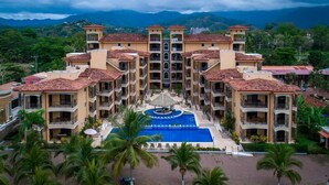 Un hôtel doté d’une piscine centrale, de nombreux balcons et offrant une vue sur les montagnes.