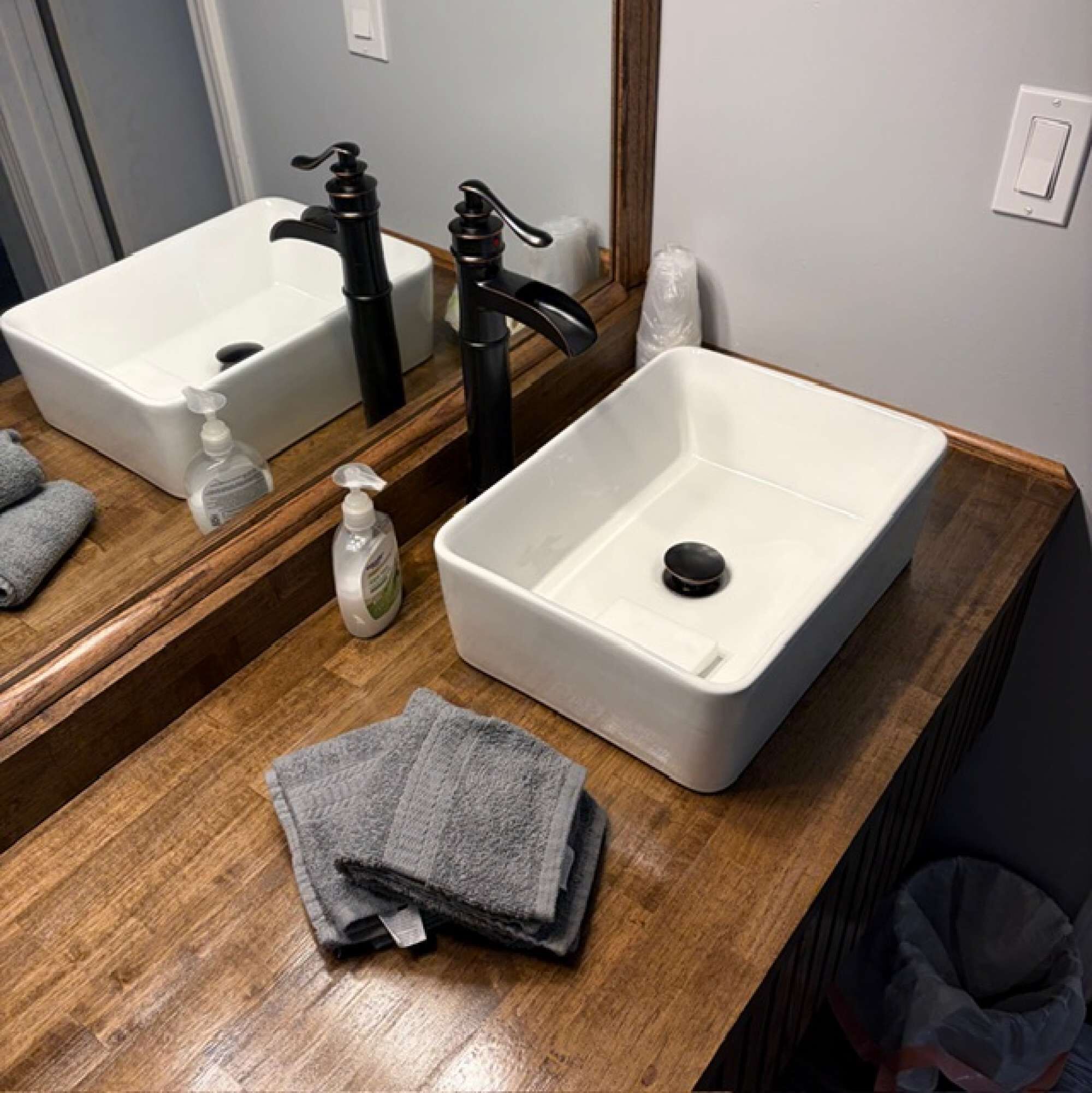 A bathroom with two sinks, a mirror, and a towel rack.