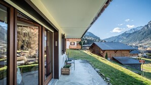 A modern house with large windows, a patio, and a view of a mountain landscape. - T3 Chatel Apartment with Mountain View, Private Terrace and Balcony (chatel)