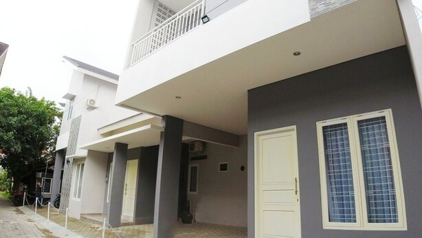 A modern two-story building with a balcony, a white door, and a window with a grid pattern. - Omah Bondi Family Homestay by FH Stay (Yogyakarta)