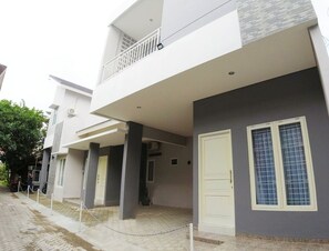 A modern two-story building with a balcony, a white door, and a window with a grid pattern. - Omah Bondi Family Homestay by FH Stay (Yogyakarta)