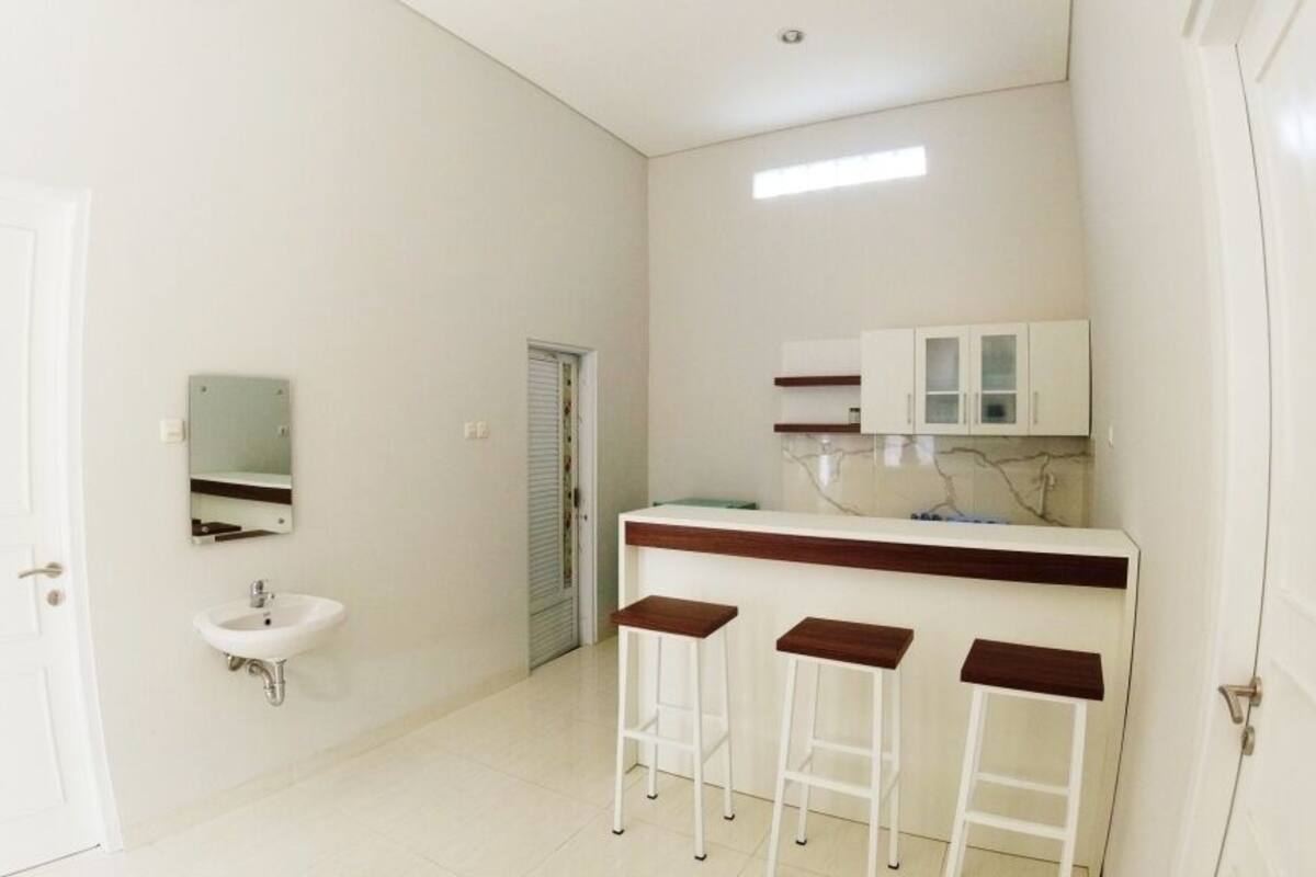 A bathroom with a sink, mirror, and three stools.