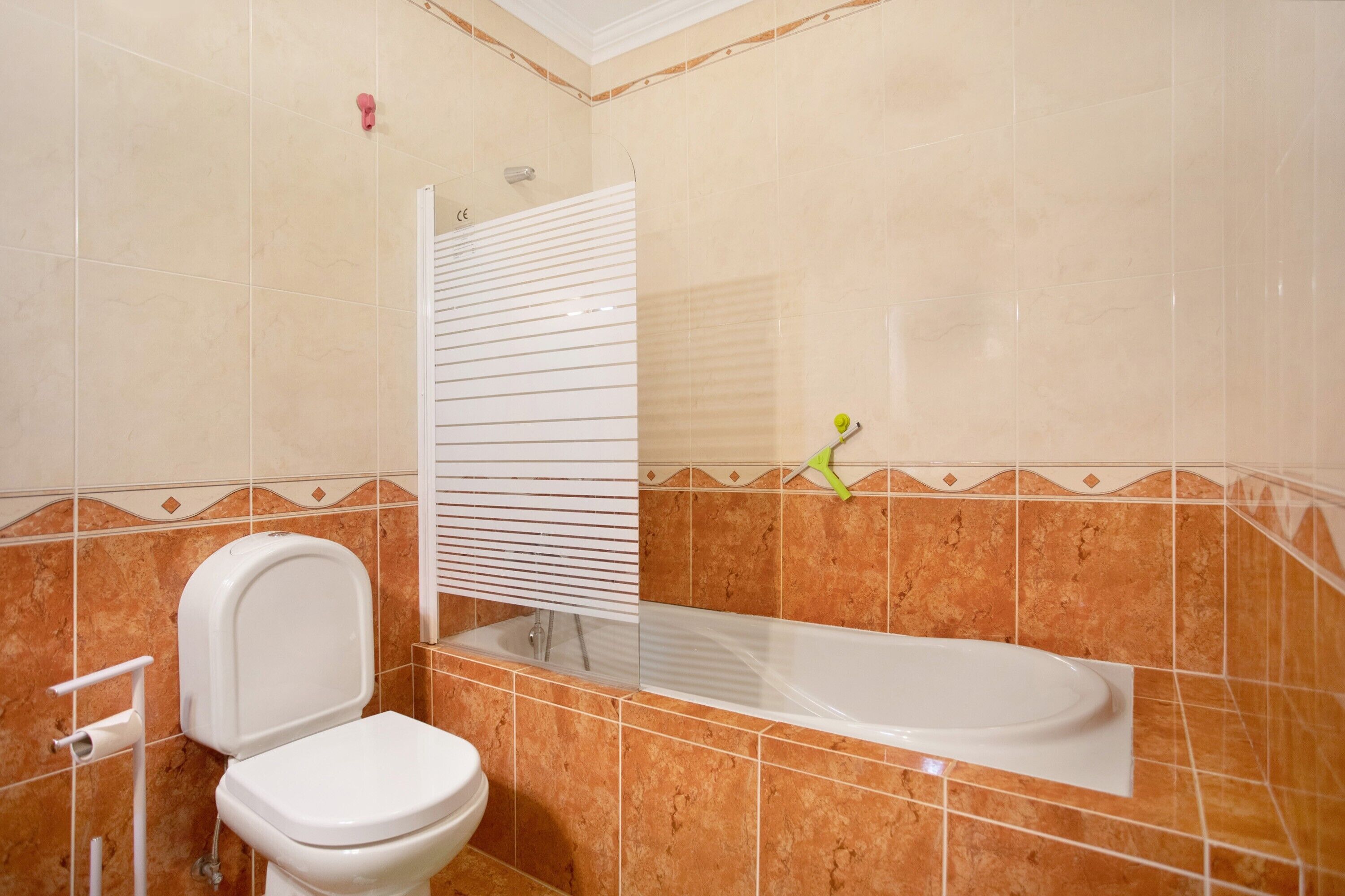 A bathroom with a toilet, a bathtub, and a shower curtain.
