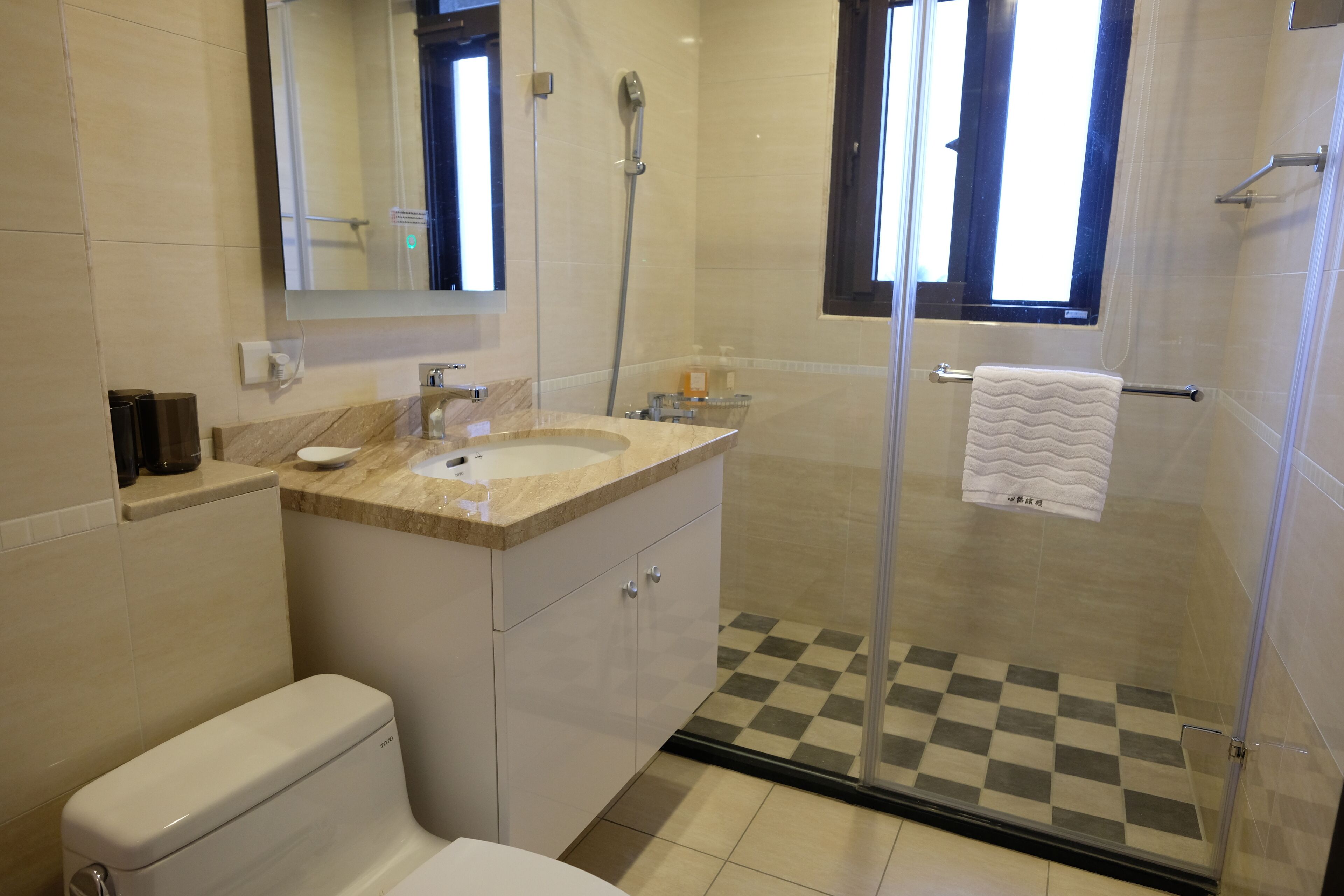 Ein modernes Badezimmer mit Toilette, Waschbecken und Duschbereich.