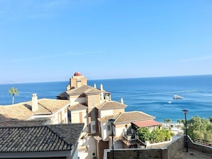 Un edificio costero con techos de teja, una estructura en forma de cúpula y vistas al mar.