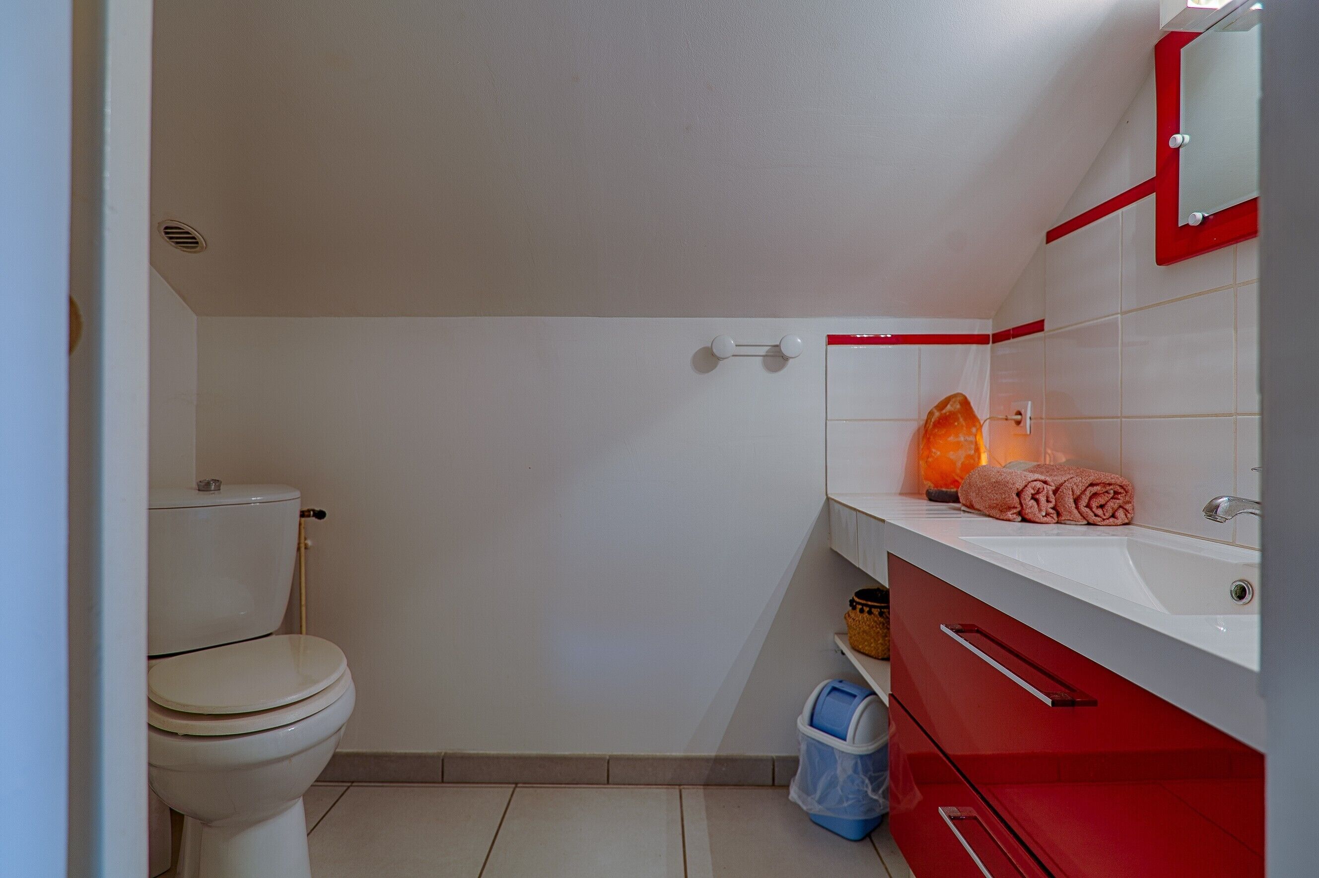 Ein Badezimmer mit Toilette, Waschbecken, Spiegel und Handtuch.