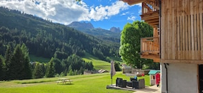 A wooden cabin with a balcony overlooking a mountainous landscape.