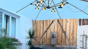 A hot tub with a wooden deck, a rustic wall, and a wooden bench. - Vacation Home "Jacuzzi-Sauna Station 7 Laux" with Private Terrace, Shared Garden & Wi-Fi (Theys)