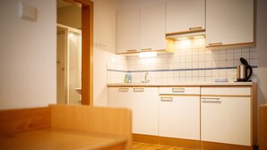 A kitchen with white cabinets, a wooden countertop, and a tiled backsplash. - Apartment 'Alpengruss Natura' with Mountain View, Shared Garden and Wi-Fi (Prato alla Drava)
