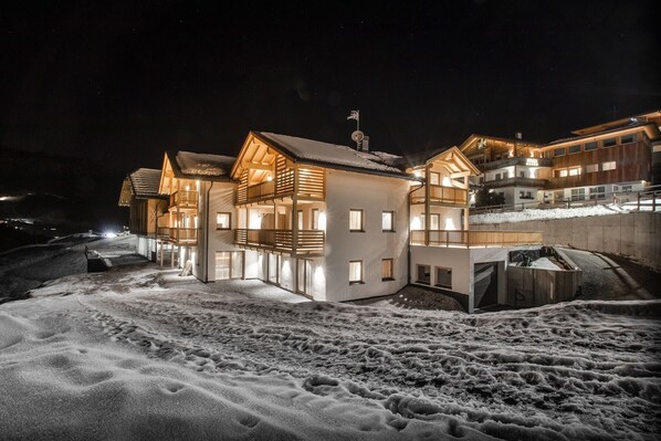 A multi-story hotel with a snow-covered ground, large windows, and a balcony.