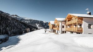 Paesaggio montuoso innevato con case di legno.