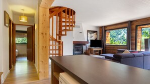 Un intérieur moderne avec un escalier en bois, un téléviseur à écran plat et un canapé.