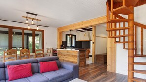 Un salon moderne avec un canapé, une table basse et un escalier menant à un niveau supérieur.
