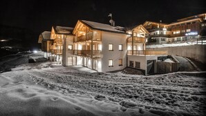 Un edifici cobert de neu amb diversos balcons i un telefèric visible al fons.