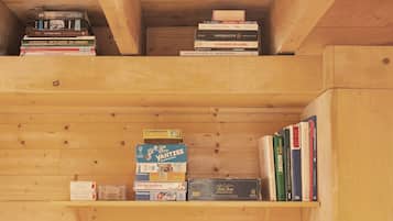 Une bibliothèque en bois contenant divers livres et jeux.