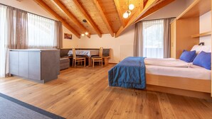 Une pièce avec un plafond en bois, un lit, un bureau et un canapé.