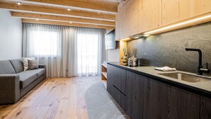 Een moderne keuken met donkere kastjes, een zwarte kraan en een aanrecht.