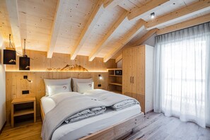 A wooden bedroom with a bed, bedside tables, and built-in shelving.