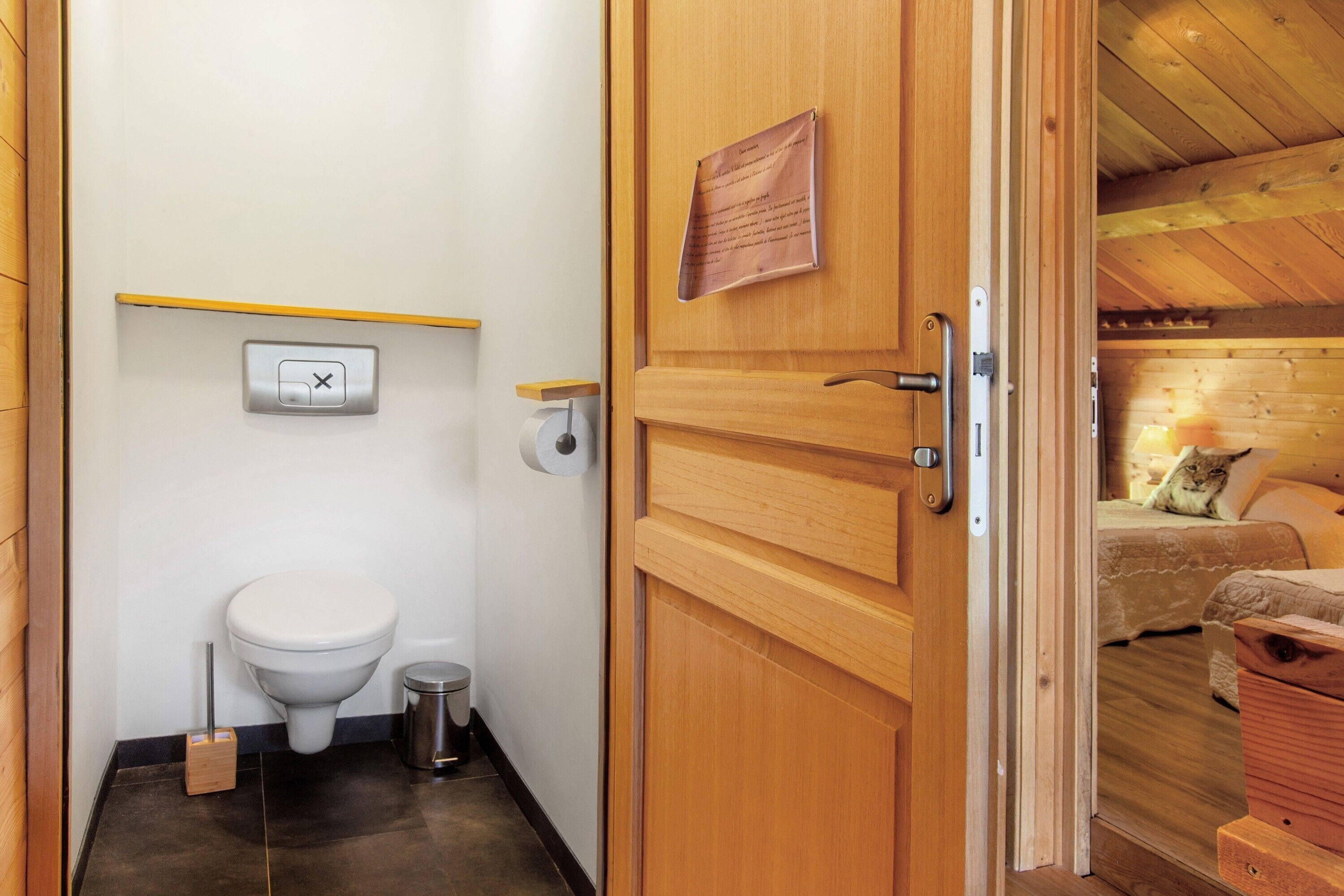 Une petite salle de bain comprenant des toilettes, une poubelle et un porte-rouleau de papier toilette.