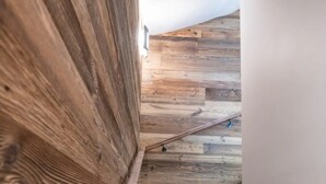 Eine Treppe mit Holzbalken und Geländer, die nach oben führt.