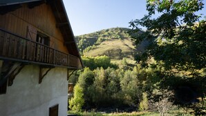 A wooden building with a balcony overlooking a forested hillside. - Apartment 'Appartement 8' with Mountain Views, Shared Garden and Wi-Fi (Saint-Sorlin-d'Arves)
