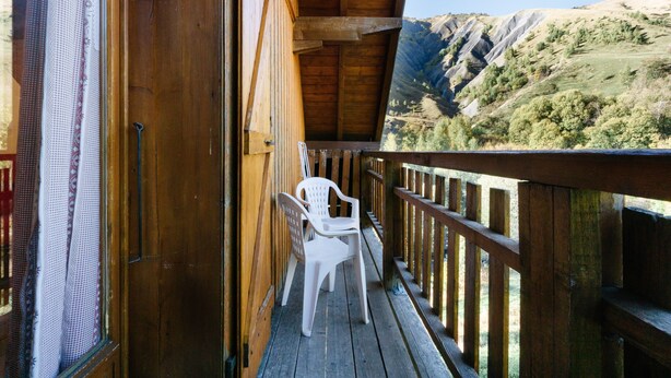 A wooden balcony with a view of a mountainous landscape. - Apartment 'Appartement 8' with Mountain Views, Shared Garden and Wi-Fi (Saint-Sorlin-d'Arves)