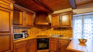 A kitchen with wooden cabinets, a microwave, a coffee maker, an oven, and a sink.