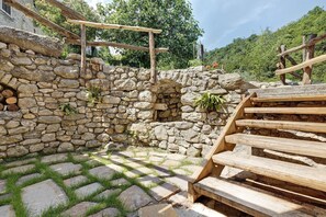 Una pared de piedra con escalones de madera que conducen a una construcción de madera.