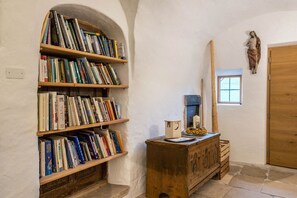 Um quarto com estante, um armário de madeira, uma estátua e uma porta de madeira.