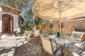A patio with a round table, chairs, and a large umbrella. - Country House 'Paco's Resort  Luxury Villa 31' with Sea View, Wi-Fi and Air Conditioning (Paxoi)
