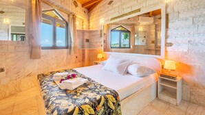 Una camera da letto con un letto, comodini, uno specchio e una finestra.