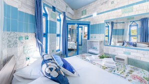 Een hotelkamer met een bed, een badkamer, een spiegel en uitzicht.