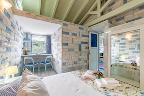 Un dormitorio con cama, escritorio y ventana.