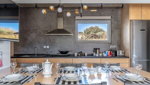 A modern kitchen with a dining area set for six. - Country House 'A The' with Mountain View, Shared Terrace and Wi-Fi (Tinos)