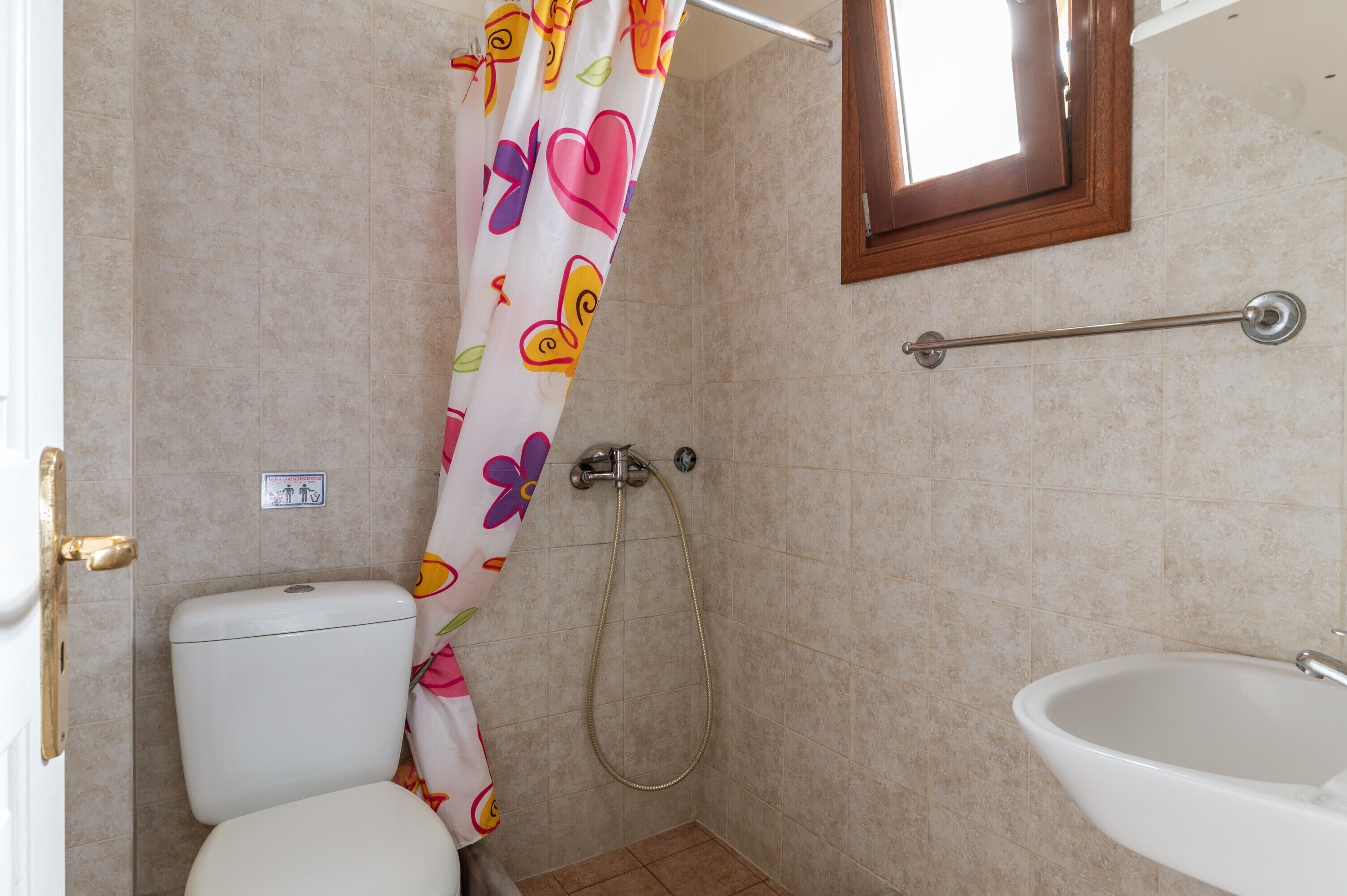 Un baño con inodoro, ducha y lavamanos.