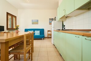 A compact living space with a dining area, kitchenette, and a sofa.