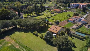 An aerial view of a residential area with houses, green lawns, and trees. - Apartment 'Mare Etrusco 3' with Shared Garden and Wi-Fi (Populonia)