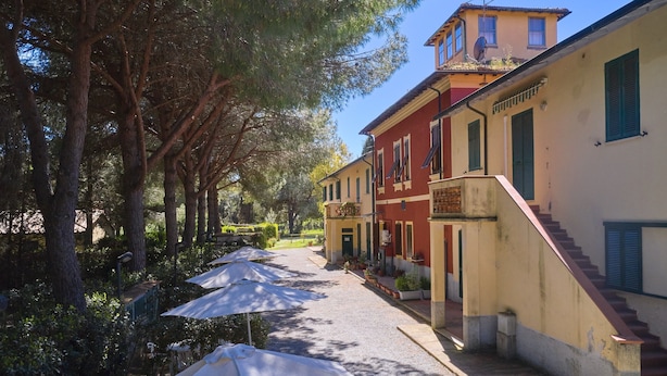 A street with buildings, trees, and umbrellas. - Apartment 'Mare Etrusco 2' with Shared Garden and Wi-Fi (Populonia)
