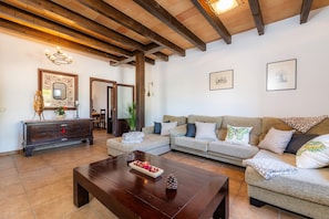 A living room with a sofa, a wooden coffee table, and a mirror on the wall. - Rural House 'Villa Es Coll Doret' with Private Pool, Private Terrace and Wi-Fi (Porto Cristo)