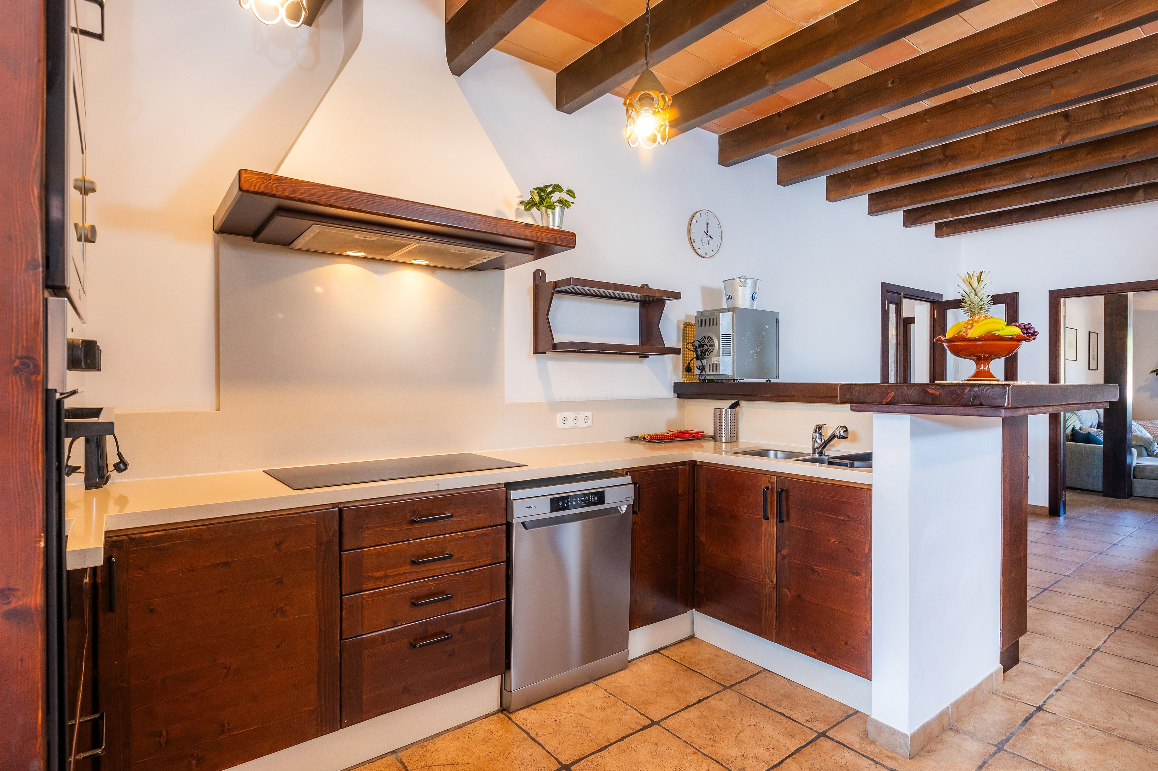 Eine moderne Küche mit Holzschränken, einem eingebauten Geschirrspüler und einer zentralen Kochinsel mit Spüle.