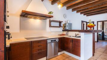 Eine moderne Küche mit Holzschränken, einem eingebauten Geschirrspüler und einer zentralen Kochinsel mit Spüle.