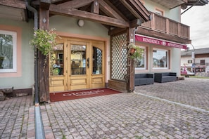 A building with a wooden facade, a sign reading 'Residence Apartments,' and outdoor seating.