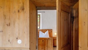Une pièce en bois avec un lit, une table de chevet et une fenêtre.
