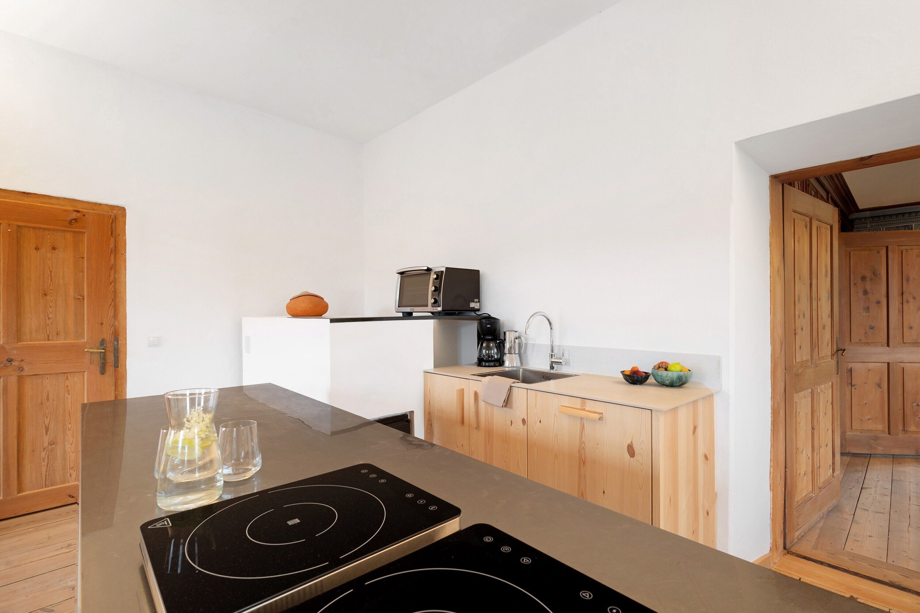Uma cozinha moderna com ilha central, armários de madeira, micro-ondas e pia.
