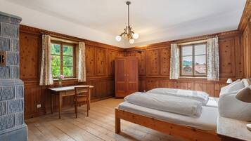 A wooden-paneled room with a bed, desk, and wardrobe.