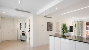 Una cocina moderna con armarios blancos, encimera negra y estufa integrada.
